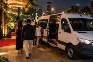 Van branca esperando convidados na entrada de um evento decorada com luzes ao anoitecer